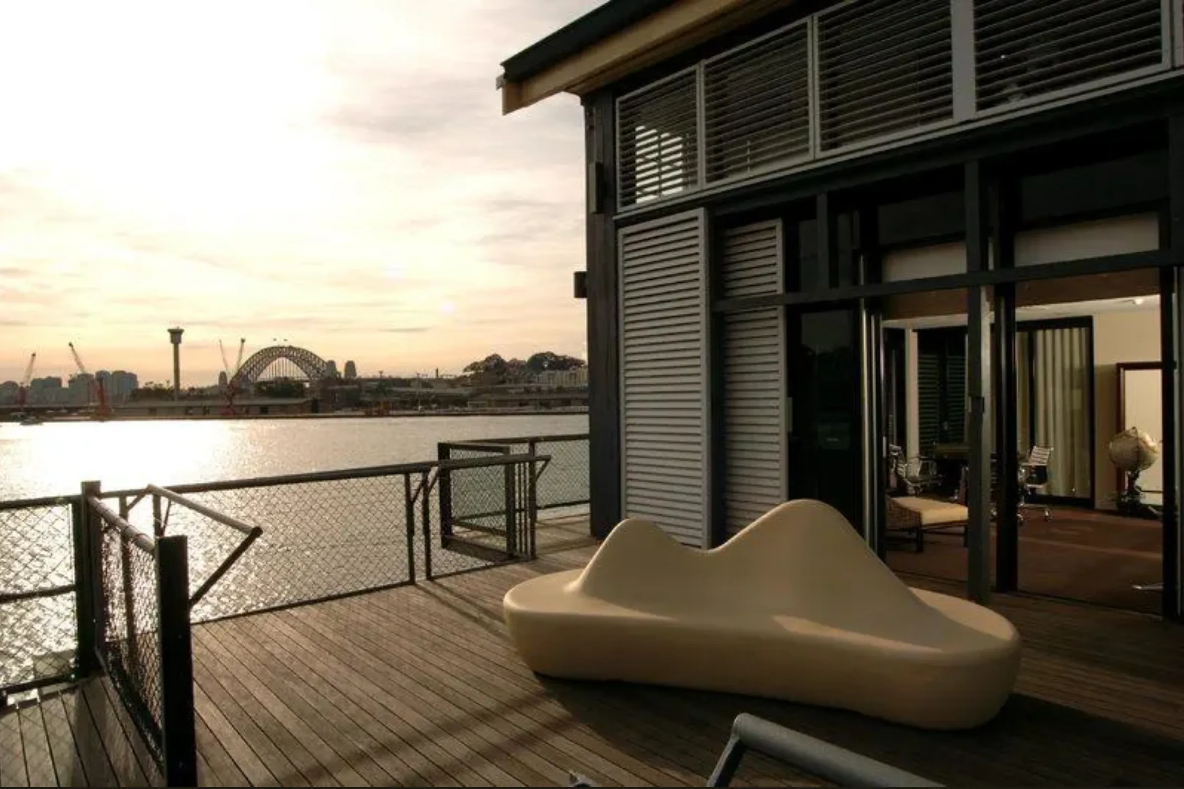 Jones Bay Wharf waterfront deck at dusk with Sydney Harbour Bridge in the background